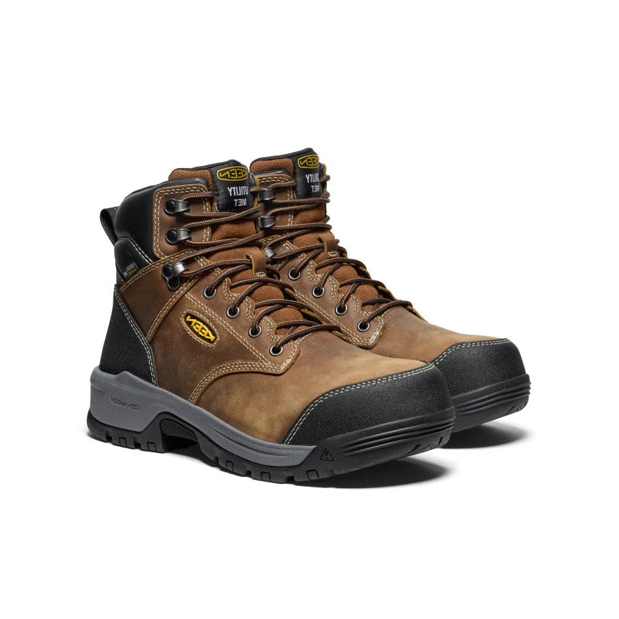 Pair of brown work boots with black soles on a white background