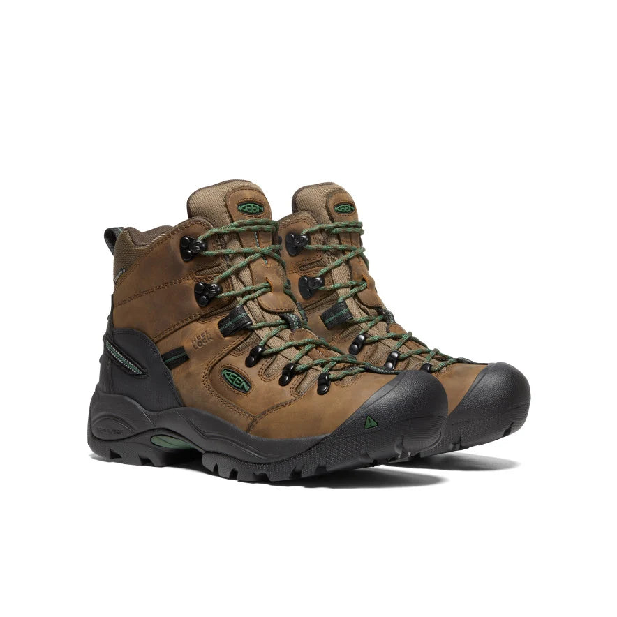 Brown hiking boots with green laces on a white background