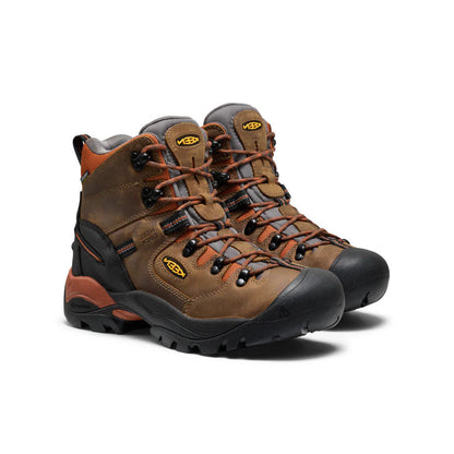 Pair of brown hiking boots with orange accents on a white background